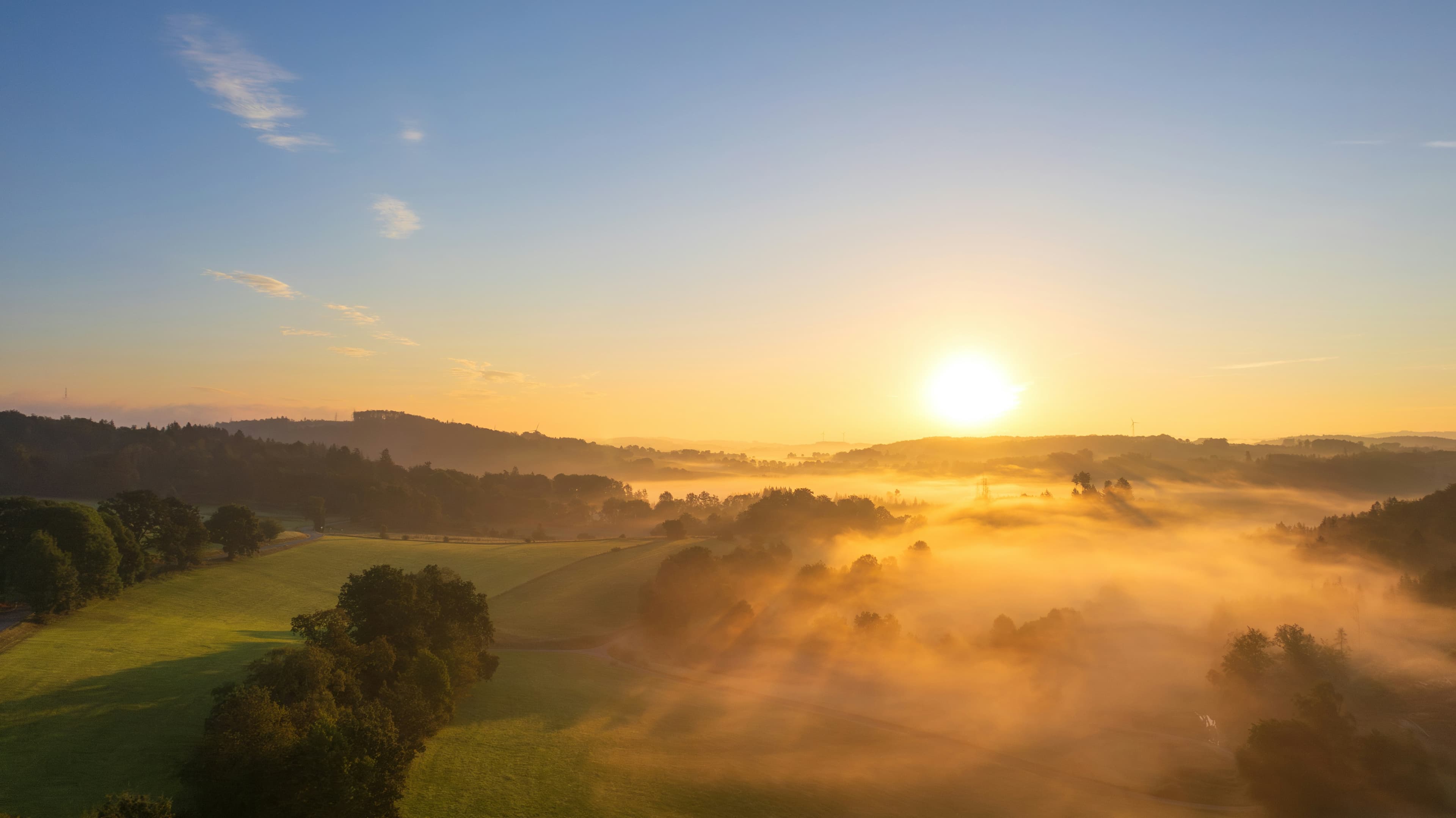 Sunrise over the rolling hills and low fog of southern Chester County, Pennsylvania, shot from the air